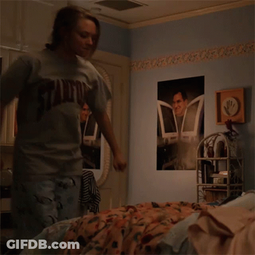 Girl In Stanford Shirt Standing In Bedroom GIF