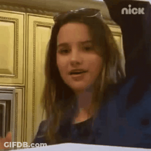 Girl In Sunglasses With Arm Up In Kitchen GIF