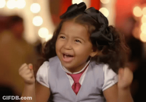 Girl In Vest And Tie Cheering With Fist Up GIF