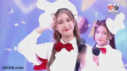 Girl In White Hat And Red Bow Tie Smiling In Front Of Workpoint Logo GIF