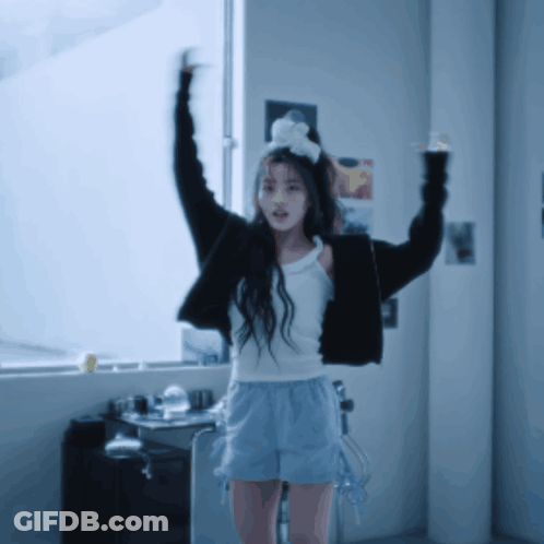 Girl In White Tank Top And Shorts With Arms Up GIF