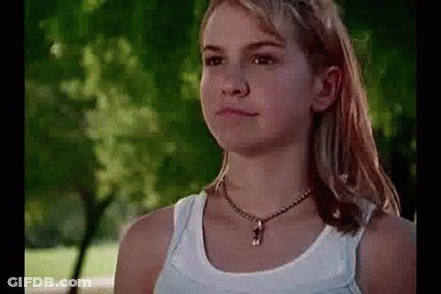 Girl In White Tank Top Standing In Park GIF