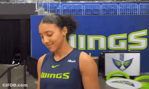 Girl In Wings Jersey In Front Of Blue Wall GIF