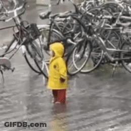 Girl In Yellow Raincoat In Rain With Bikes GIF