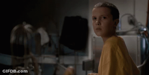 Girl In Yellow Shirt Sitting In Dark Room GIF