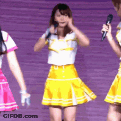 Girl In Yellow Skirt Holding Microphone GIF