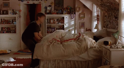 Girl Making Bed In Bedroom With Pictures On Walls GIF