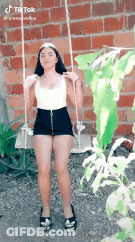 Girl On Swing By Brick Wall GIF