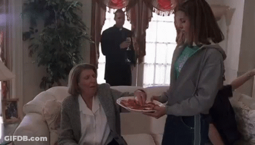 Girl Scout Serving Food To Older Woman On Couch GIF
