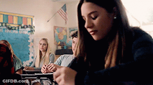 Girl Sitting At Desk In Classroom GIF