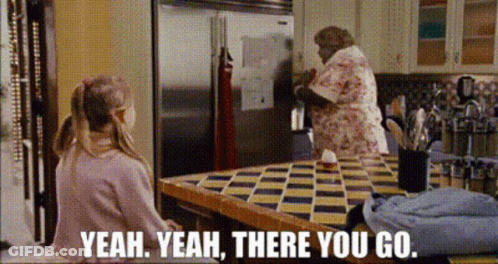 Girl Sitting At Refrigerator Table With Woman Behind GIF