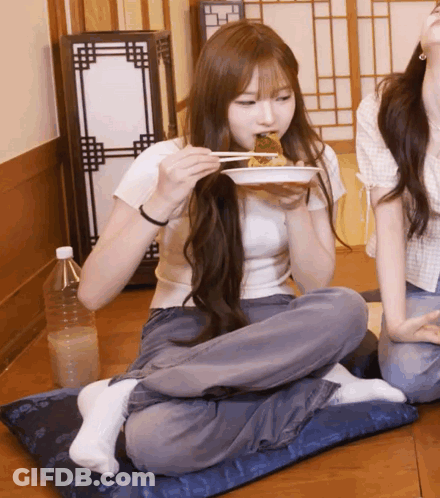 Girl Sitting On Pillow Eating Food With Chopsticks GIF