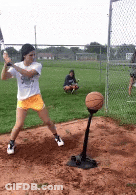 Girl Swinging Bat At Basketball On Tee GIF