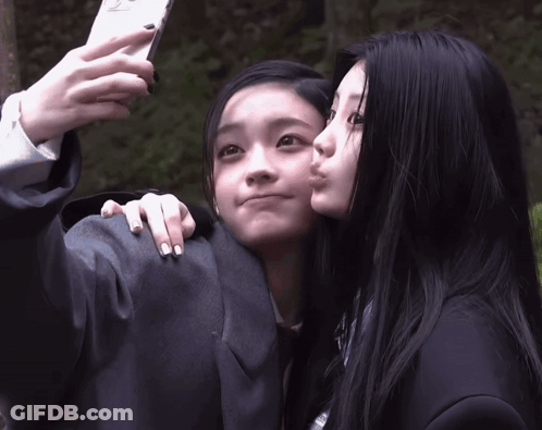 Girl Taking Selfie With Kiss On Cheek GIF