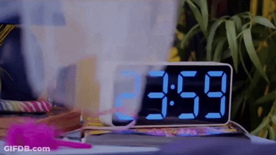 Girl Waking To Digital Clock Alarm GIF