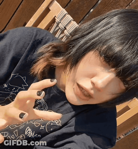 Girl With Black Nails And Black Shirt With Cartoon Drawing GIF