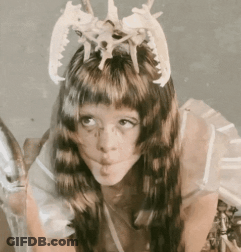Girl With Crown Of Bones Blowing A Kiss GIF