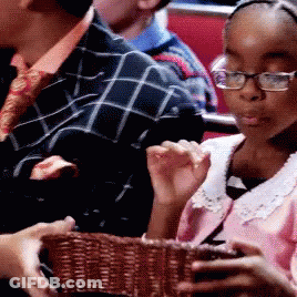 Girl With Glasses Holding Basket In Crowd GIF