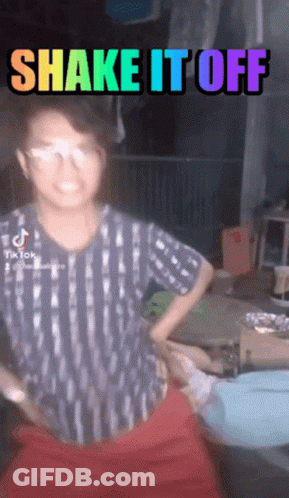 Girl With Glasses Next To Rainbow Sign Saying Shake It Off GIF
