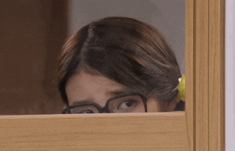 Girl With Glasses Peeking Through The Window GIF