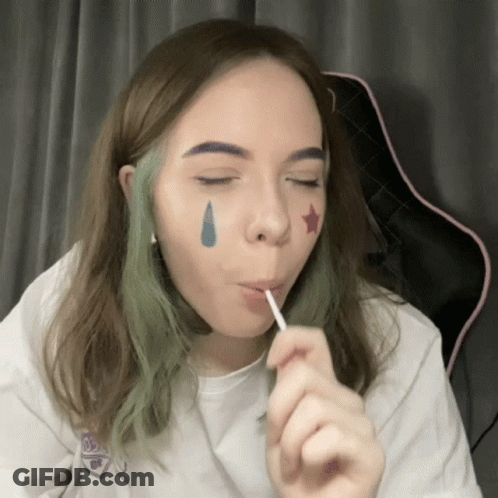 Girl With Green Hair Eating Lollipop With Star On Face GIF