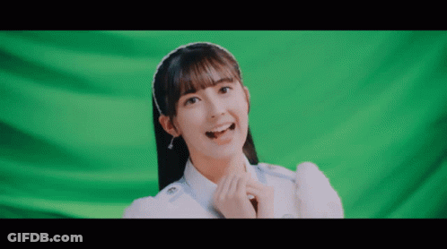 Girl With Headband Smiling In Front Of Green Screen GIF