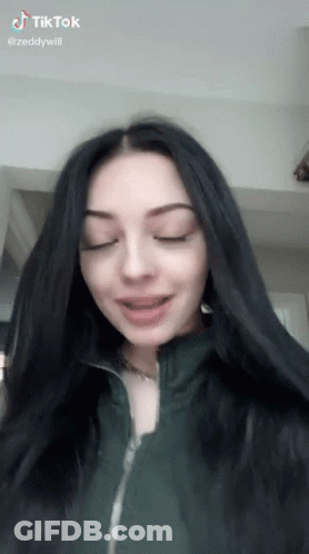 Girl With Long Black Hair In Green Jacket Making Funny Face GIF