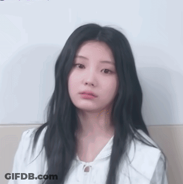 Girl With Long Black Hair In White Shirt Looking At Camera GIF