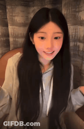 Girl With Long Dark Hair Smiling In Grey Hoodie GIF