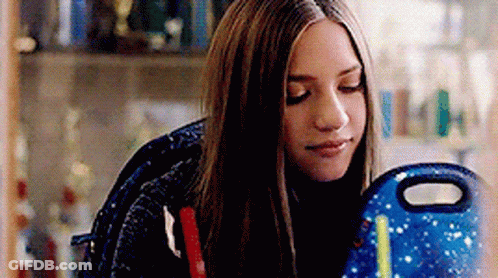 Girl With Long Hair Sitting With Backpack And Lunch Bag GIF