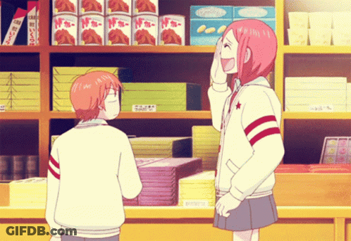 Girl With Pink Hair Laughing Next To Boy In Front Of Shelf With Boxes GIF