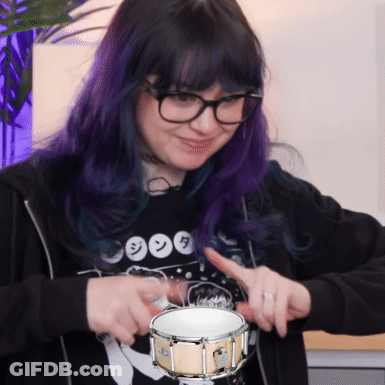 Girl With Purple Hair And Glasses Holding Drum GIF