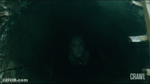 Girl With Red Hair And Black Tie In Dark Hallway GIF