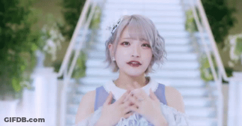 Girl With Short Hair Standing On Stairs Hands Folded GIF