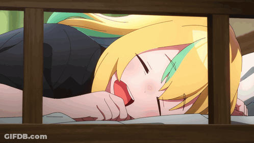 Girl With Yellow Hair And Green Highlights Lying On Bed GIF