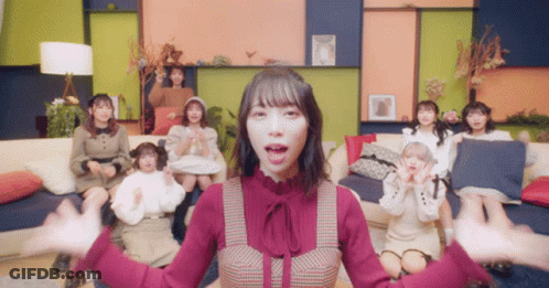Girls Sitting On Couch One In Red Dress GIF