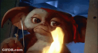 Gizmo Holding Knife With Flame In Mouth GIF