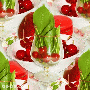 Glass Of Cherries With Green Leaves GIF