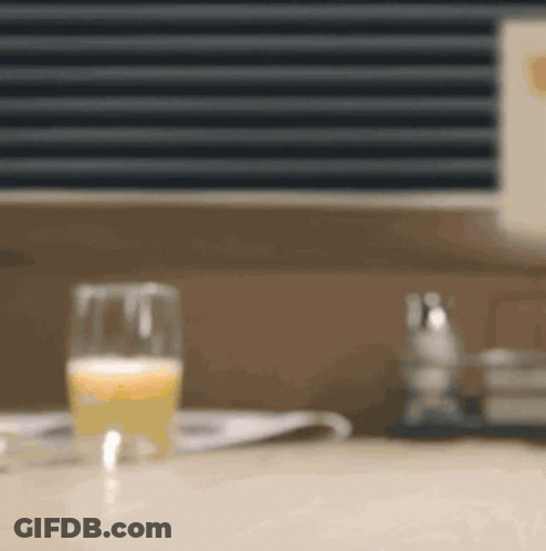 Glass Of Orange Juice Next To Newspaper GIF