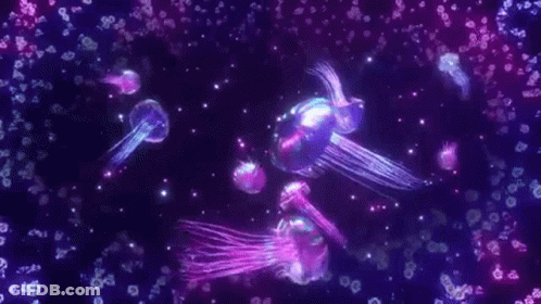 Glowing Jellyfish Swimming In Dark Water GIF