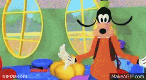 Goofy From Mickey Mouse Clubhouse Is Sitting On A Bed Holding A Pumpkin . GIF
