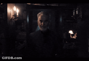 Gray-Haired Man With Beard In Dark Room GIF