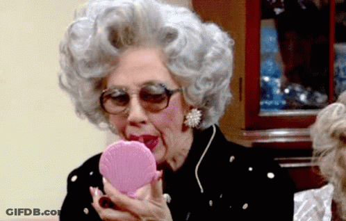Gray-Haired Woman Looking In Pink Mirror GIF