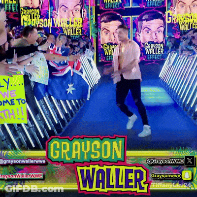 Grayson Waller Is Walking Down A Blue Carpet In Front Of A Crowd Of People GIF