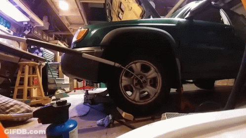 Green Car Being Repaired In Garage GIF