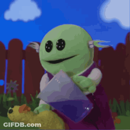 Green Cartoon Character Holding Purple Bag By Fence GIF