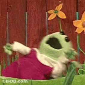 Green Cartoon Character With Flower Dancing In Garden GIF
