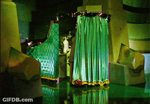 Green Curtain Hanging From Ceiling In Dark Room GIF