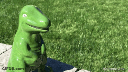 Green Dinosaur Statue Sitting On Sidewalk GIF