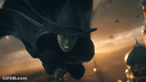 Green-Faced Witch In Black Hat Smiling GIF